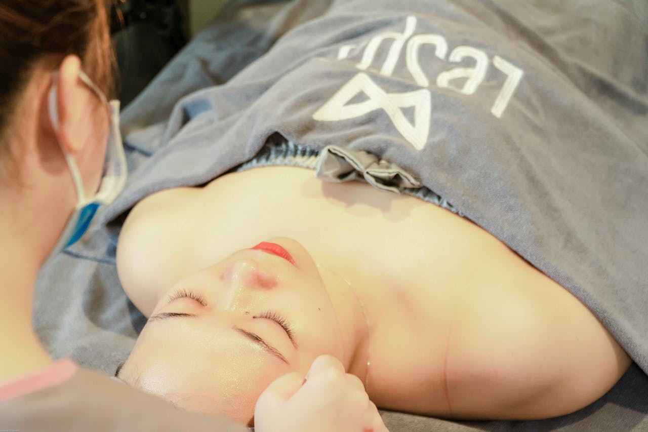 A woman enjoys a soothing facial massage at a spa, promoting wellness and relaxation.